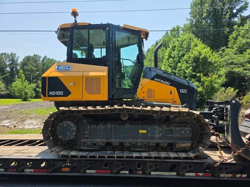 Hyundai HD100 dozer with blade attachment on flatbed trailer transport