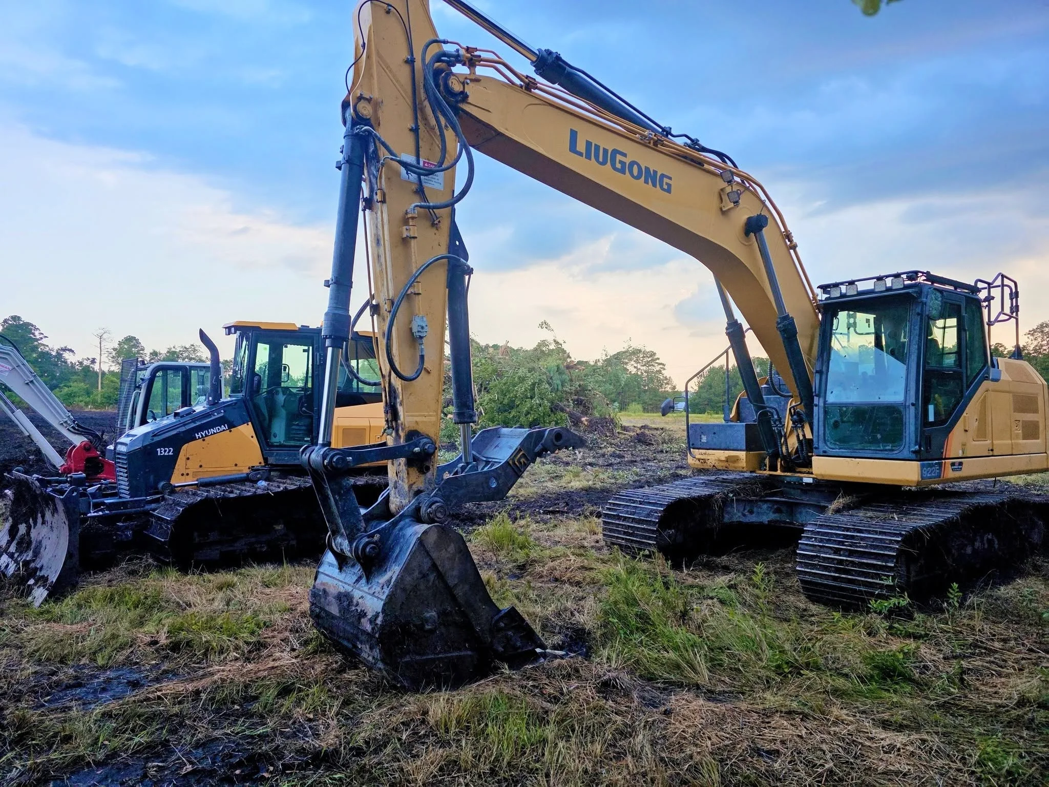 LiuGong excavator and Hyundai compact excavator on cleared dirt site with hydraulic buckets