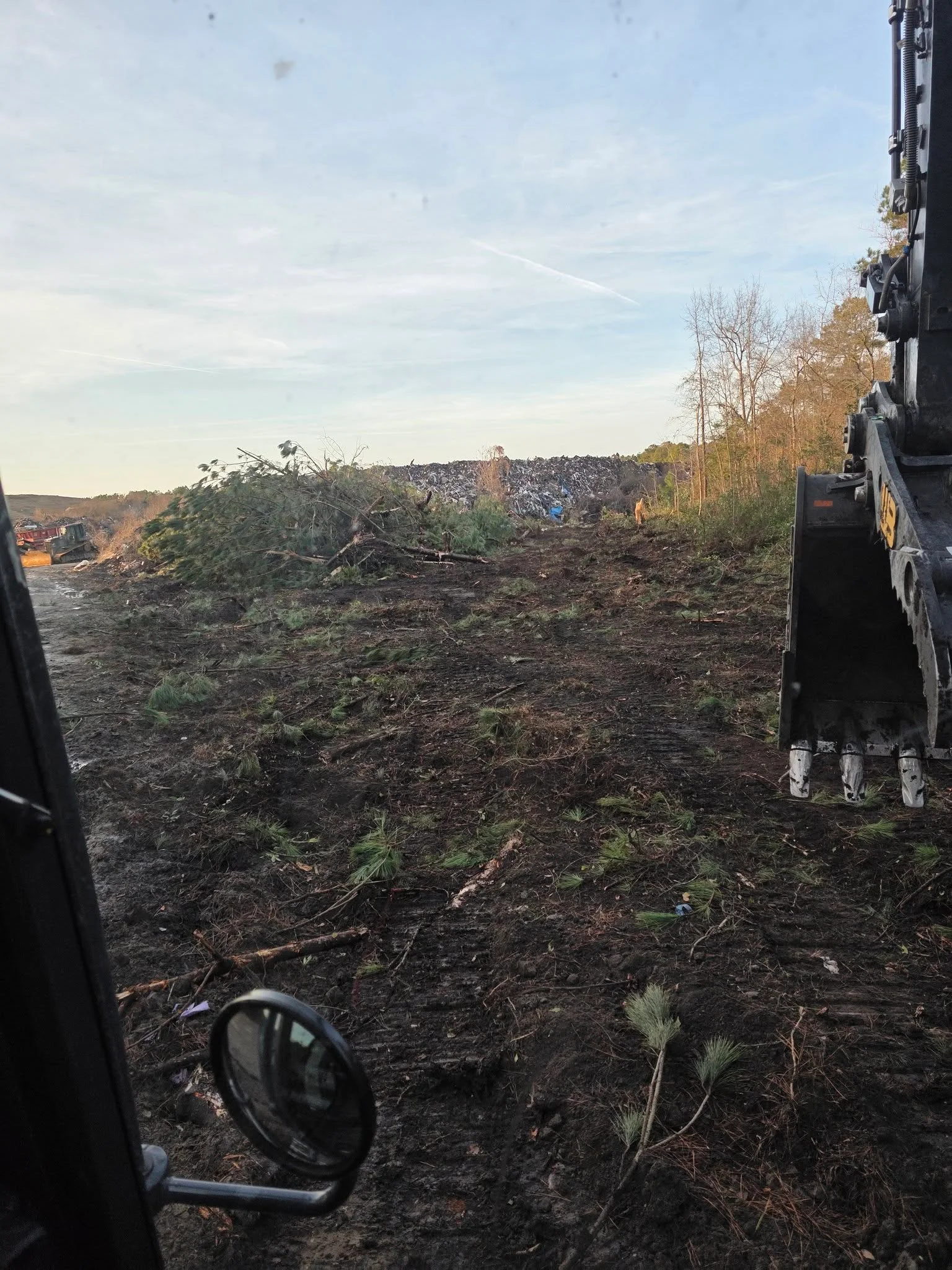 Cleared hillside with removed trees and vegetation, heavy equipment on site